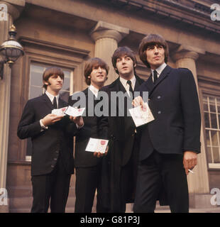 Die Beatles zeigen ihre MBE-Insignien auf dem Vorplatz, nachdem sie von der Queen empfangen wurden. L-R Ringo Starr, John Lennon, Paul McCartney und George Harrison. Stockfoto