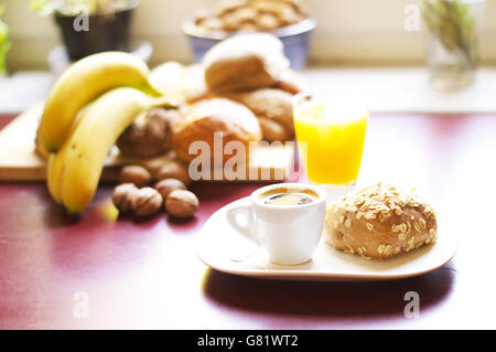 Tasse Kaffee, Brot und Obst für ein perfektes Frühstück im Büro Stockfoto
