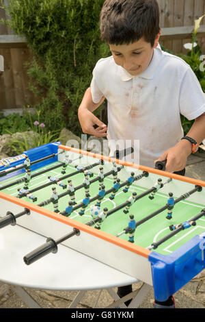 Junge spielt Tischfußball Stockfoto