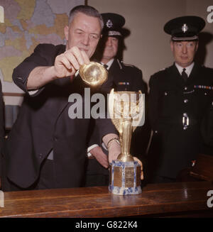 Detective Chief Inspector William Little ersetzt die Spitze der wiedergewonnenen WM in Cannon Row Polizeistation, London. Die Trophäe wurde gestohlen, während sie in der Westminster Central Hall ausgestellt wurde. Die Trophäe wurde von einem Hund namens Pickles unter einer Hecke in Zeitung in seinem Besitzer, David Corbett Vorgarten eingewickelt gefunden. Stockfoto