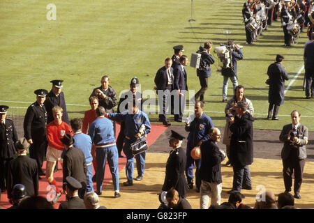 Die siegreichen Spieler Jack Charlton und George Cohen aus England kommen nach dem Spiel vom Spielfeld. Manager Alf Ramsey schüttelt George Cohens Hand. Hinter Cohen mit einer Kamera steht der englische Schiedsrichter Ken Aston. Stockfoto