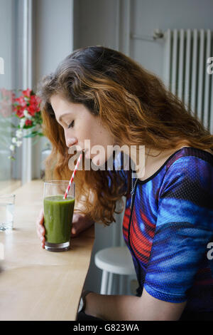 Seitenansicht der jungen Frau trinkt Saft am café Stockfoto