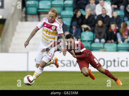 Fußball - International Friendly - Schottland - Katar - Easter Road. Der schottische Johnny Russell (links) und der katarische Hamid Ismail kämpfen während eines internationalen Freunds in der Easter Road, Edinburgh, um den Ball. Stockfoto