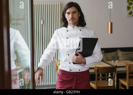 Porträt von lächelnden männlichen Chef stehend durch Glastür Stockfoto