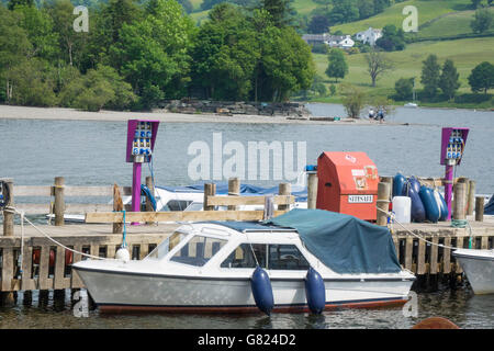 Elektrisch betriebene kleine Motorboote mieten mit Ladestationen auf dem Steg an Coniston Wasser Cumbria in England Stockfoto