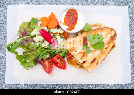 Café Mittagessen einen Chicken Jalfrezi-Sandwich auf Naan-Brot mit Salat Stockfoto