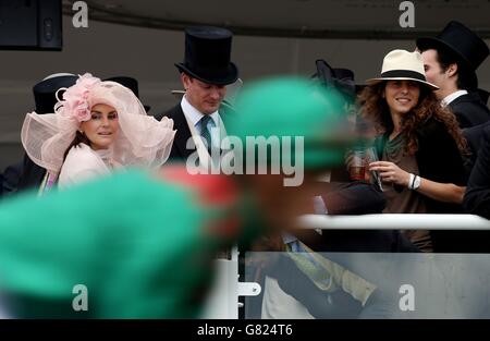 Pferderennen - 2015 Investec Derby Festival - Derby Day - Epsom Racecourse. Rennbesucher beobachten, wie ein Läufer am Derby Day des Investec Derby Festivals 2015 auf der Epsom Racecourse, Epsom, postet. Stockfoto