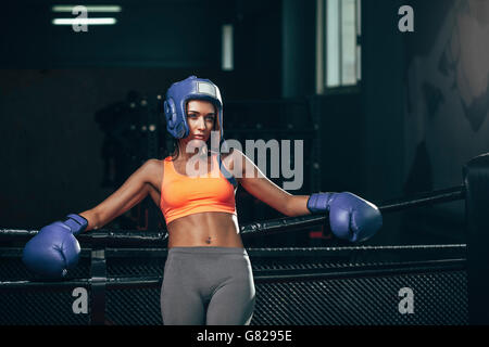 Boxerin stützte sich auf Seilen im Boxring Stockfoto