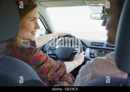 Glückliches Paar sahen einander während der Reise in Auto Stockfoto