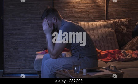 Seitenansicht der Mann leidet unter Kopfschmerzen sitzend auf sofa Stockfoto
