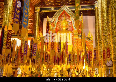 Gebetsfahnen gegen Buddhastatuen im Wat Chedi Luang Tempel Stockfoto