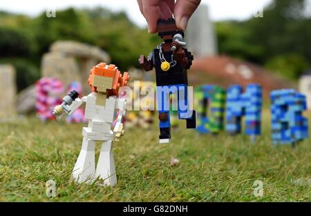 Die Modellbauerin Hannah Reed platziert in der brandneuen Miniland-Szene des Glastonbury Festival in Legoland, Windsor, eine LEGO Figur von Kanye West neben eine Figur von Florence Welch. Stockfoto