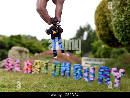 Die Modellbauerin Hannah Reed platziert in der brandneuen Glastonbury Festival Miniland-Szene im Legoland, Windsor, eine LEGO Figur von Kanye West neben das Glastonbury-Schild. Stockfoto