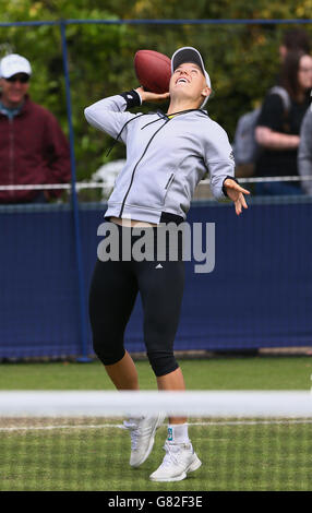 Die Dänin Caroline Wozniacki erwärmt sich vor ihrem Halbfinalspiel gegen Belinda Bencic am siebten Tag des AEGON International im Devonshire Park, Eastbourne, mit einem amerikanischen Fußball auf den Übungsplätzen. Stockfoto