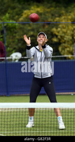 Die Dänin Caroline Wozniacki erwärmt sich vor ihrem Halbfinalspiel gegen Belinda Bencic am siebten Tag des AEGON International im Devonshire Park, Eastbourne, mit einem amerikanischen Fußball auf den Übungsplätzen. Stockfoto