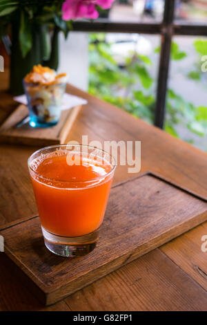 Frisch gepresster Grapefruitsaft auf hölzernen Fensterleiste. Detox-Lebensstil. Vitaminspritze. Stockfoto