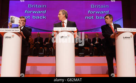 John Prescott hält das Wahlmanifest der Labour-Partei auf, und Tony Blair (C) und Gordon Brown blicken darauf. Stockfoto