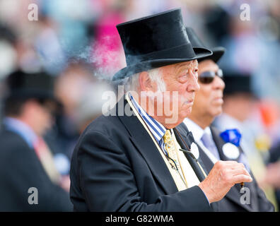 Ein Rennfahrer im Royal Enclosure raucht am zweiten Tag des Royal Ascot Meeting 2015 auf der Ascot Racecourse, Berkshire, eine Zigarre. Stockfoto