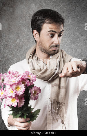 Mann in der Liebe mit einem Blumenstrauß suchen beobachten mit Sorge. Vertikales Bild. Stockfoto