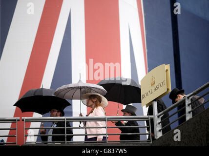 Rennfahrer, die am fünften Tag des Royal Ascot Meeting 2015 auf der Ascot Racecourse, Berkshire, Regenschirme halten. Stockfoto