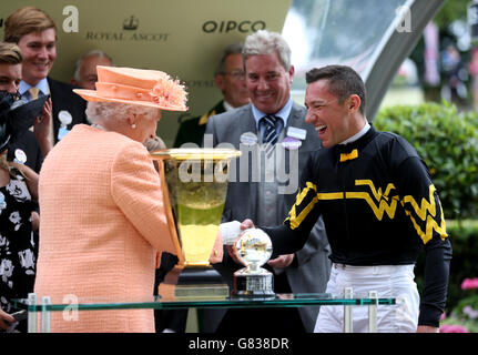 Königin Elizabeth II., bevor sie am fünften Tag des Royal Ascot Meeting 2015 auf der Ascot Racecourse, Berkshire, dem siegreichen Jockey Frankie Dettori die Trophäe für die Diamond Jubilee Stakes überreicht hat. Stockfoto