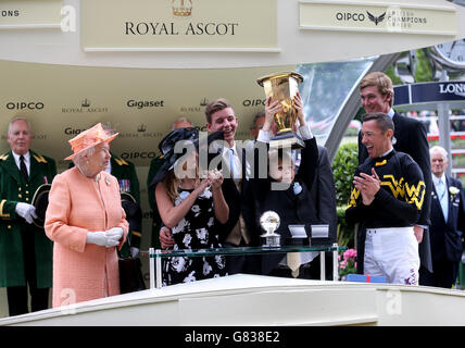 Der Jockey Frankie Dettori (rechts) und Queen Elizabeth II (links) sehen sich an, als die siegreichen Verbindungen der ungearbeiteten Mannschaft die Trophäe nach dem Sieg bei den Diamond Jubilee Stakes am fünften Tag des Royal Ascot Meeting 2015 auf der Ascot Racecourse, Berkshire, heben. Stockfoto