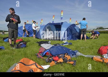 Festivalbesucher schlagen ihre Zelte auf dem Glastonbury Festival auf der Worthy Farm in Somerset auf. Stockfoto