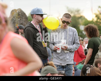 Glastonbury Festival 2015 - Vorbereitungen. Festivalbesucher atmen Gas aus einem Ballon ein Stockfoto