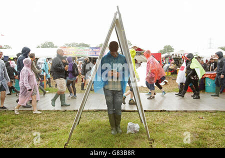 Festivalbesucher im Regen beim Glastonbury Festival, auf der Worthy Farm in Somerset. Stockfoto