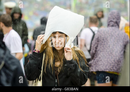 Festivalbesucher im Regen beim Glastonbury Festival, auf der Worthy Farm in Somerset. Stockfoto