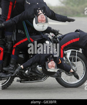 Training mit den Royal Signals White Helmets - Blandford Camp. Lance Corporal Julie Jones hängt sich von einem Motorrad ab. Stockfoto