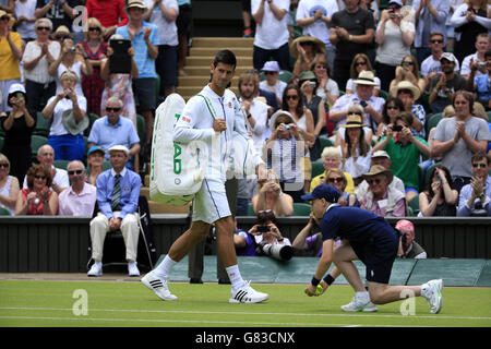 Novak Djokovic geht vor seinem Spiel gegen Philipp Kohlschreiber in der ersten Runde im Herreneinzel am ersten Tag der Wimbledon Championships beim All England Lawn Tennis und Croquet Club in Wimbledon auf den Mittelplatz. Stockfoto