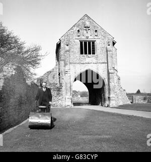 Ein Mitarbeiter des Ministeriums für Öffentliche Gebäude und Arbeiten mäht das Gras in Cleeve Abbey, Nord Somerset, in Vorbereitung für die Sommer-Invasion von Tausenden von Besuchern. Die Zisterzienserabtei wurde 1188 von William, Earl of Roumare, gegründet. Stockfoto