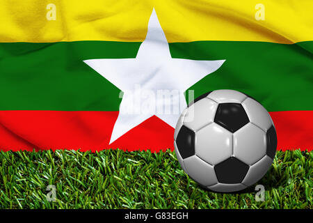 3D Fußball in Wiese mit Myanmar Flagge als Hintergrund gerendert Stockfoto