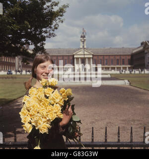 Eine Armvoll wunderschöner gelber Rosen, die Marlene Walker, 20, aus Edwalton Nottinghamshire, für eine der Ausstellungen auf der Chelsea Flower Show trug, die diese Woche auf dem Gelände des Royal Hospital, Chelsea, stattfindet. Stockfoto