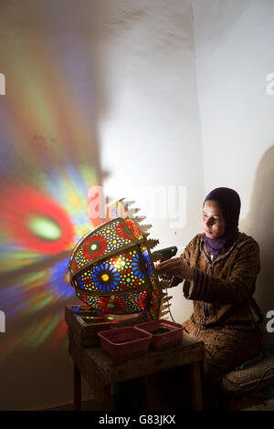 Ein Handwerker schafft traditionelle Leuchten in ihrem Atelier in Fez, Marokko. Stockfoto