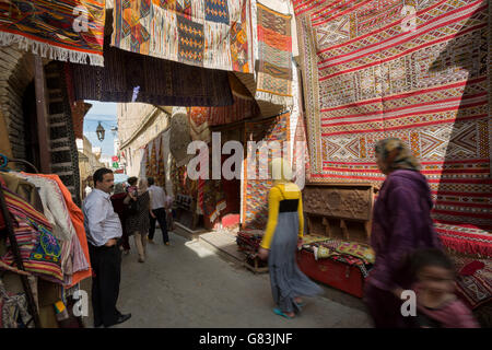 Anwohner Strich durch den Teppich gesäumten Gassen der Medina von Fes in Marokko. Stockfoto
