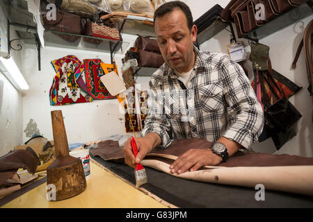 Ein Leder-Kunsthandwerker arbeitet in seiner Werkstatt in Marrakesch Medina, Marokko. Stockfoto