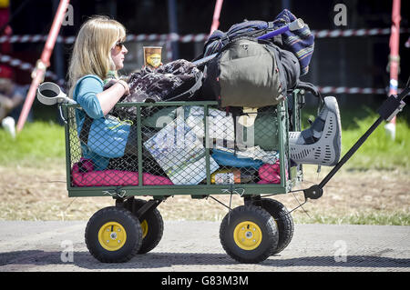 Eine Frau wird während des heißen Wetters beim Glastonbury Festival auf der Worthy Farm in Somerset in einen Wagen gezogen. Stockfoto