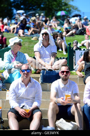 Am zweiten Tag der Wimbledon Championships am All England Lawn Tennis und Croquet Club in Wimbledon schützen sich die Zuschauer vor der Sonne auf Murray Mount. Stockfoto