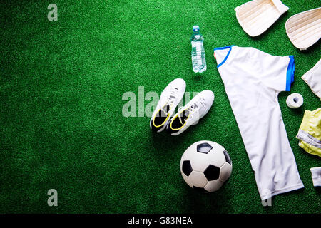 Fußball, Stollen und verschiedenen Fußball-Sachen gegen künstliche Stockfoto
