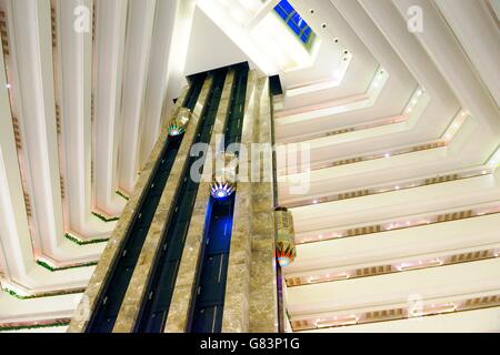 Das Sheraton Grand Doha Resort and Convention Hotel an der Corniche in West Bay, Doha, Katar. Aufzüge im zentralen Atrium Stockfoto