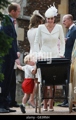 Der Herzog und die Herzogin von Cambridge mit Prinz George und Prinzessin Charlotte drängten zu ihrer Taufe in einem Vintage-Kinderwagen, den die Königin für zwei ihrer eigenen Kinder verwendete, als sie die Kirche St. Mary Magdalene in Sandringham, Norfolk, Als Prinzessin Charlotte wird vor der Königin und enge Familie getauft werden. Stockfoto