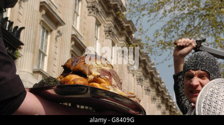 Ein Mann, der als St. George gekleidet ist, greift einen Teller Roastbeef an. Stockfoto