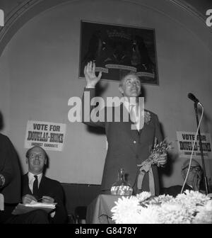 Premierminister Sir Alec Douglas-Home hält eine glückliche weiße Heidekraut, das Geschenk eines Wohlgegehers, als er der Menge in Auchterarder in Schottland zuwinkt. Er bestreitet die Nachwahlen von Kinross und West Perthshire als konservativen Kandidaten. Stockfoto