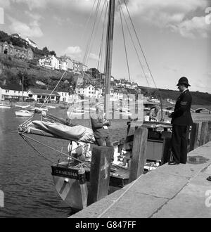 Der Sergeant SA Goldworthy von der Constabulary von Devon und Cornwall plaudert mit dem lokalen Fischer Frank Pengelly an Bord seines Bootes Ganesha in Looe, Cornwall. Stockfoto