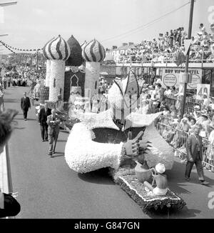 Bräuche und Traditionen - Battle of the Flowers - Jersey. Die Pfarrei St. Brelade stellt während der Battle of the Flowers in Jersey ihren „Sklave der Lampe“-Festwagen vor. Stockfoto