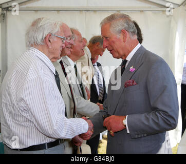 Der Prinz von Wales (rechts), Patron des Combined Operations Pilotage Parties Memorial Fund (COPP) trifft Veteranen, nachdem er bei einem Besuch auf Hayling Island in Hampshire einen Kranz an einer Gedenkstätte für COPP-Helden niedergelegt hat. Stockfoto