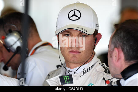 Mercedes-Pilot Nico Rosberg spricht mit Paddy Lowe in der Teamgarage, während Mechaniker an seinem Auto arbeiten, während sie am Qualifying-Tag für den Grand Prix von Großbritannien 2015 auf dem Silverstone Circuit, Towcester, trainieren. Stockfoto