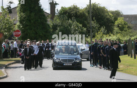 Der Sarg der Mutter von zwei Lorna Carty, ein Opfer des tunesischen Terroranschlags, wird in einem Leichenwagen getragen, begleitet von Spielern von Meath GAA und Dunderry GAA, von der Kirche der Himmelfahrt Robinstown, Co Meath. Stockfoto